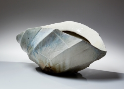 Horizontally elongated, thickly walled Tamba vessel with diagonally faceted surface and pointed ends in thick dripping ash glaze, 2015